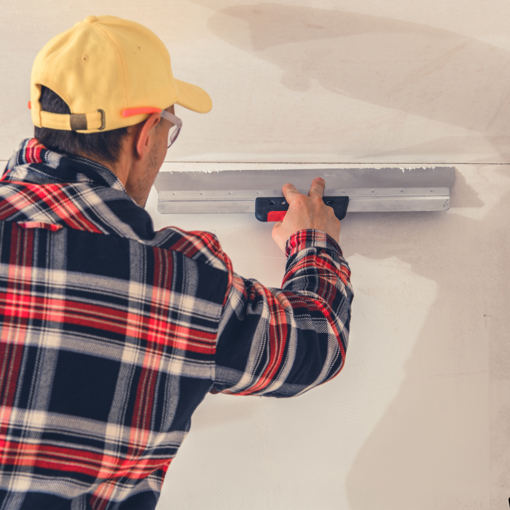 Expert drywall tapping in progress, showcasing a professional applying joint compound to drywall seams for a smooth finish.